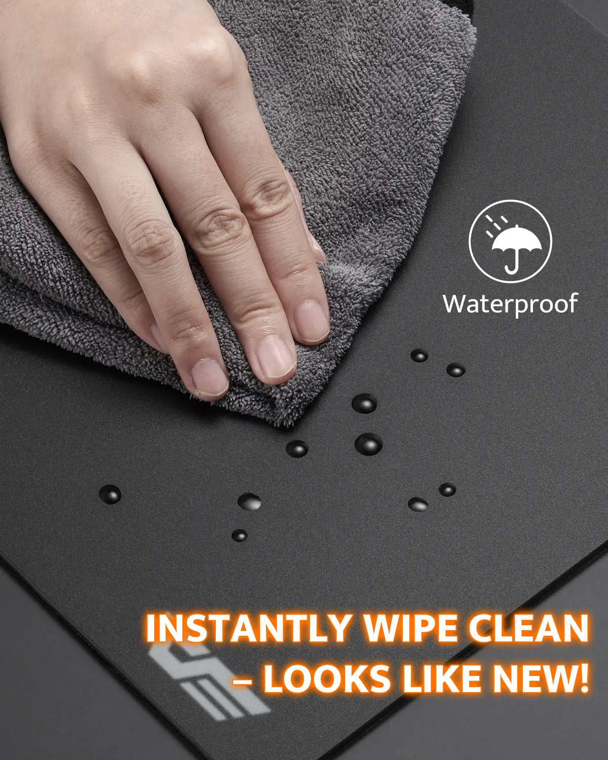 Hand using a gray cloth to wipe a black surface with waterproof and cleaning text overlay.